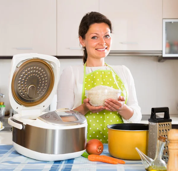 Dona de casa cozinhar arroz com multifogão — Fotografia de Stock