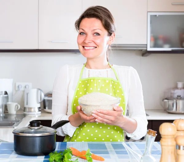 Mulher feliz cozinhar arroz com legumes — Fotografia de Stock