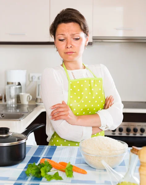 Pensive femme cuisine riz avec des légumes — Photo