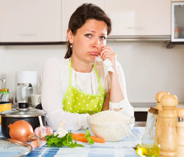 Mulher pensativa cozinha arroz com legumes — Fotografia de Stock