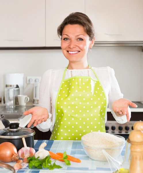 Vrouw kookt rijst in de keuken — Stockfoto