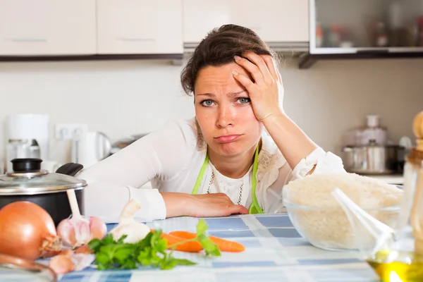 Mulher pensativa cozinha arroz com legumes — Fotografia de Stock