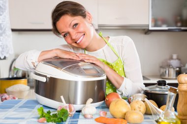 Woman cooking with multicooker clipart