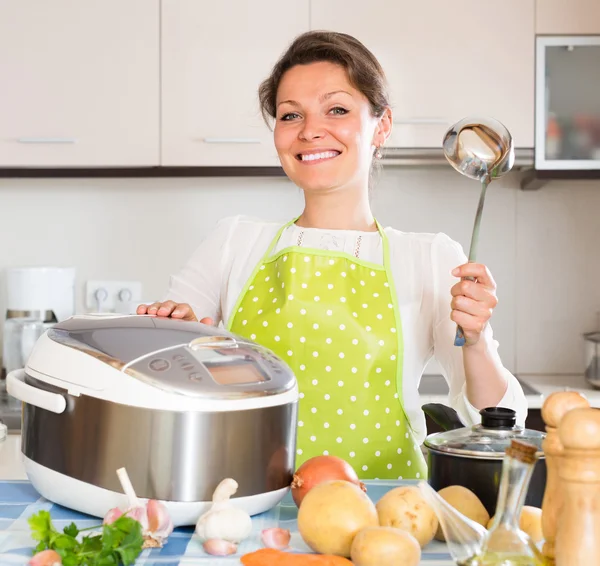 Домохозяйка готовит с мультикукером — стоковое фото