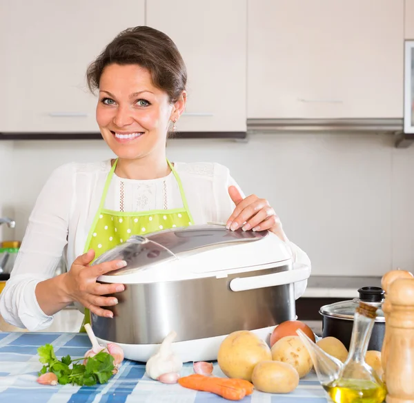 Домохозяйка готовит с мультикукером — стоковое фото