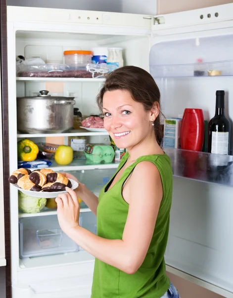 Frau isst Kuchen aus Kühlschrank — Stockfoto