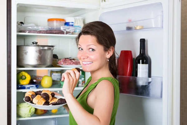 Woman eating cake from fridge — Stock Photo, Image