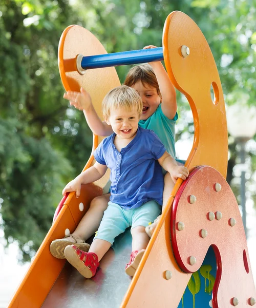 Laughing children on slide — Stock Photo, Image