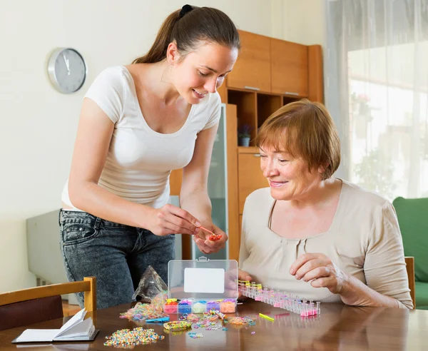 Woman to make bracelet with elastic bands — Stock Photo, Image