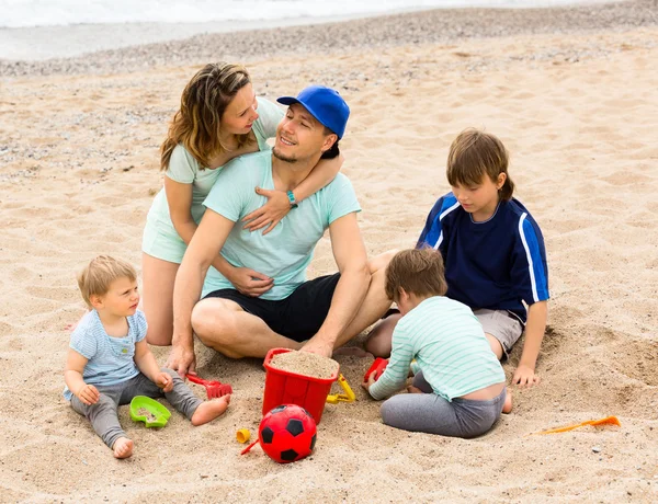 Pais com filhos sentados no mar — Fotografia de Stock