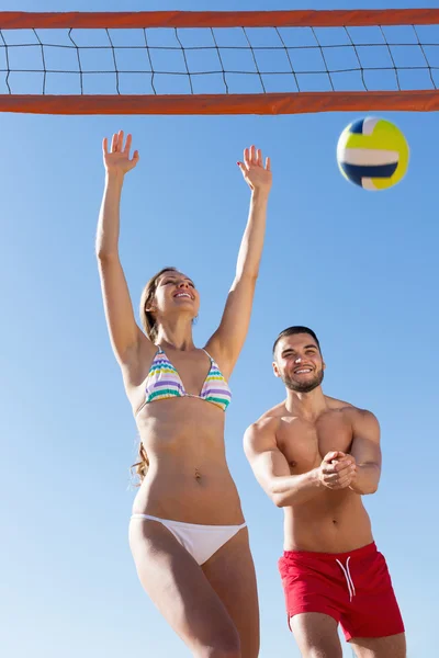 Pareja joven jugando voleibol — Foto de Stock