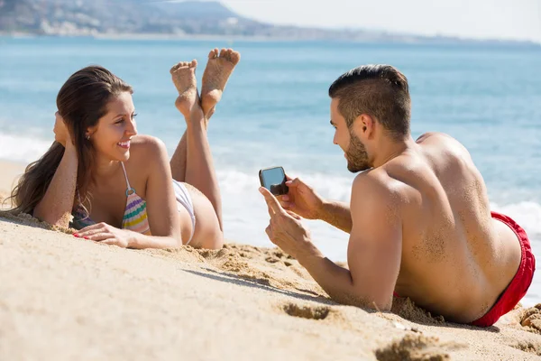 Glückliches Paar beim Fotografieren am Strand — Stockfoto