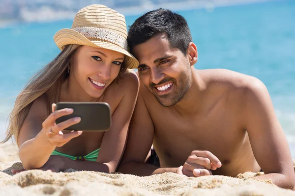 Glückliches Paar beim Fotografieren am Strand — Stockfoto