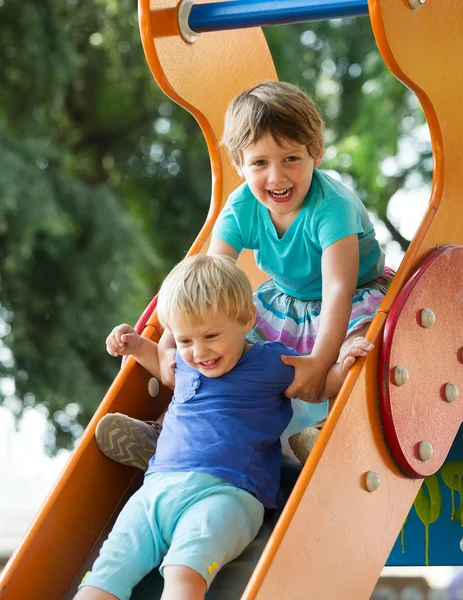 Children on slide at playground Royalty Free Stock Images