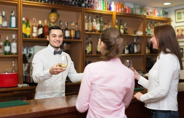 Zwei Mädchen flirten mit Barmann — Stockfoto