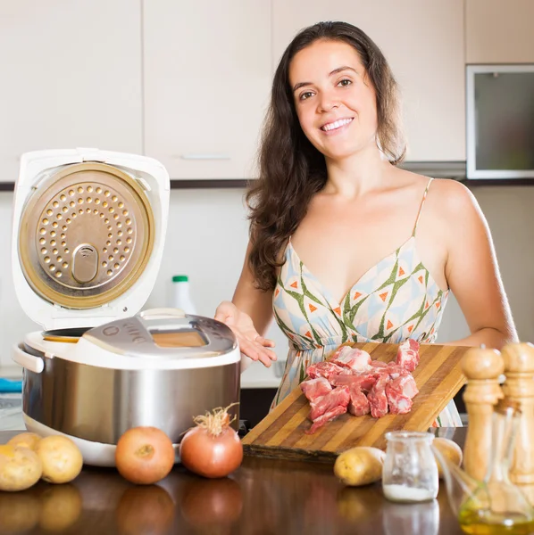 Домохозяйка готовит мясо с мультикукером — стоковое фото