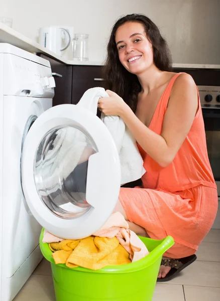 Sorrindo mulher batendo roupas brancas — Fotografia de Stock