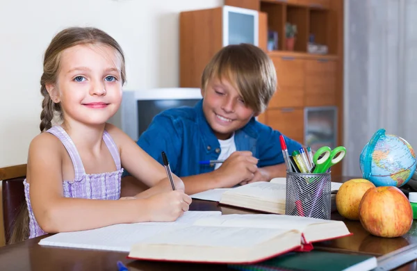 Lachende broers en zussen huiswerk — Stockfoto