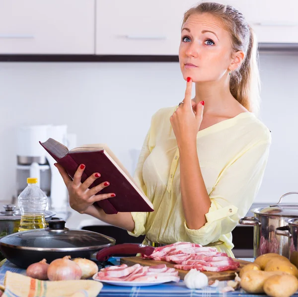 Huisvrouw koken met vlees — Stockfoto