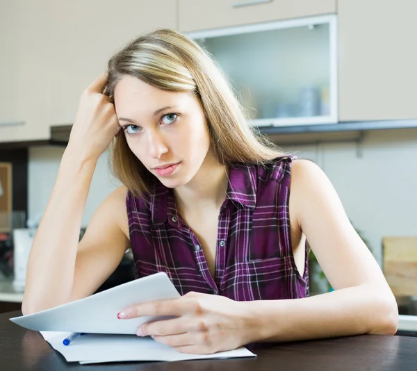 Vrouw met documenten in keuken Stockfoto