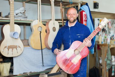 Guitar-maker at workshop clipart