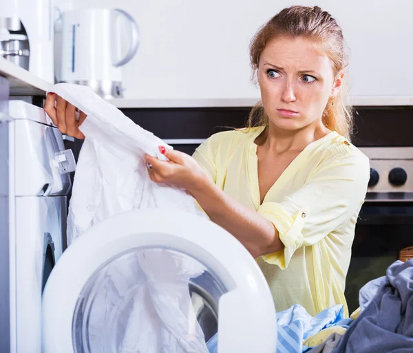 Muchacha molesta mirando ropa de cama después de la lavandería — Foto de Stock