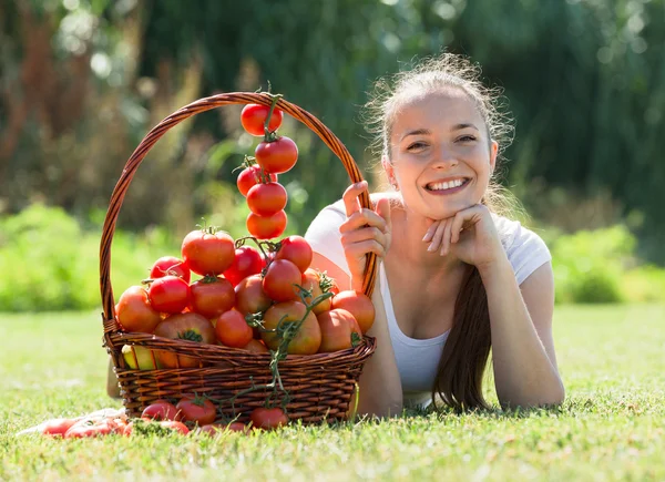 Vrouw met tomaten oogst in tuin — Stockfoto