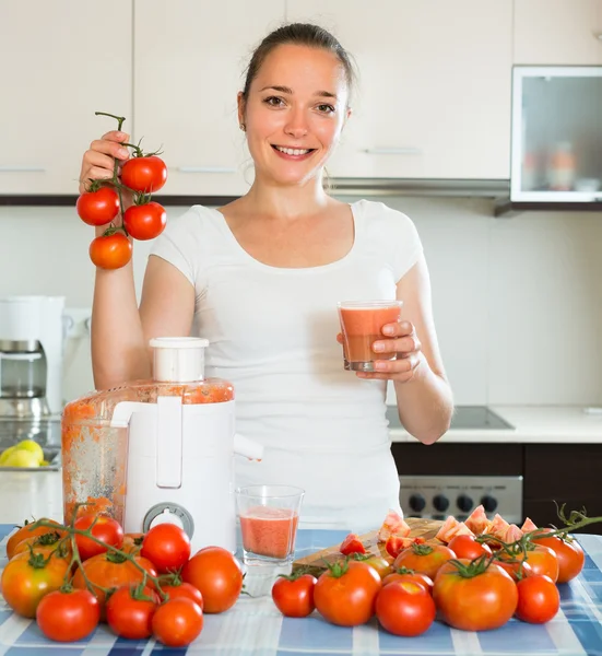 Menina feliz fazendo suco de tomate — Fotografia de Stock
