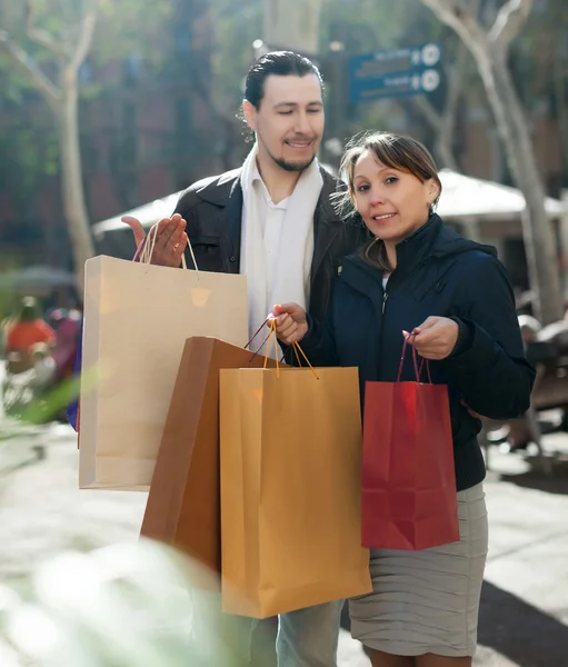 Man and woman with purchases at street — Stock Photo, Image