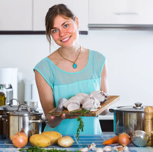Woman cooking fish in kitche — Stock Photo, Image