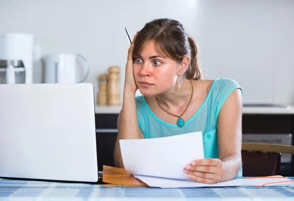 Ledsen tjej med dokument på kök — Stockfoto