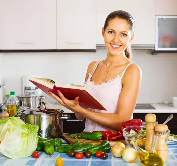 Chica de pie en la cocina con verduras — Foto de Stock