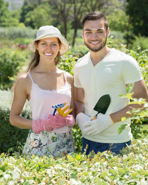 Twee lachende volwassenen in bloemen tuin — Stockfoto