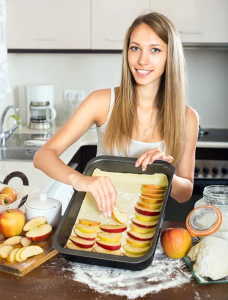 Hemmafru sätta äpplen på degen — Stockfoto