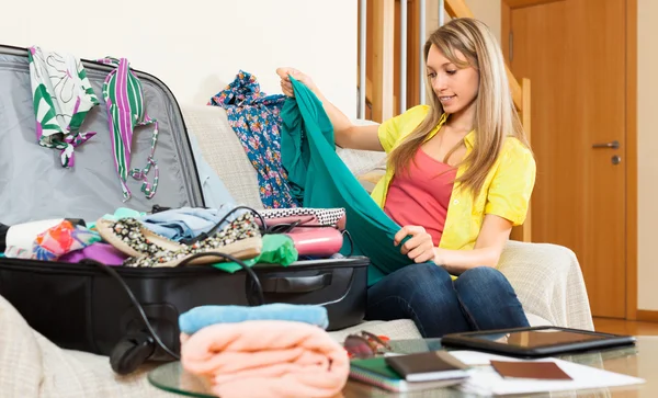 Girl trying to find place for all things in trunk — Stock Photo, Image