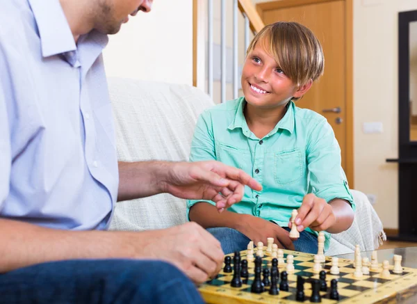 Man and teenager son playing chess — Stock Photo, Image