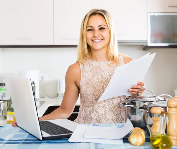 Female signing documents at the kitchen — Stock Photo, Image