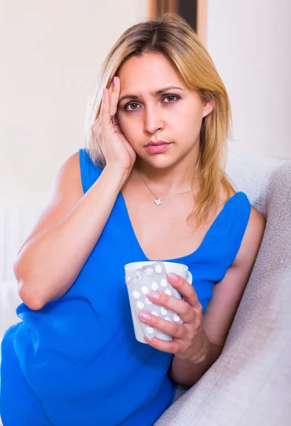 Mujer joven con pastillas en casa — Foto de Stock