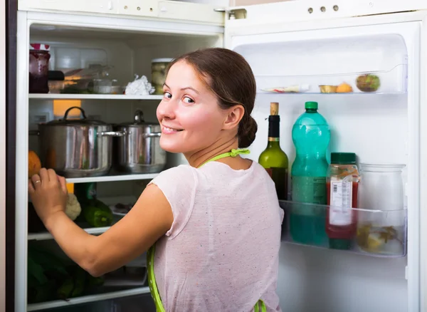 Femme au foyer près réfrigérateur rempli — Photo