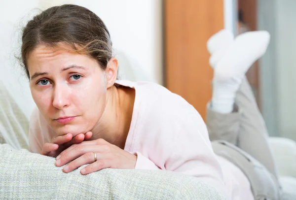 Boos vrouw zitten in binnenlandse interieur — Stockfoto