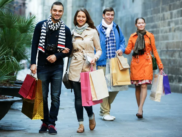 Group of young tourists with purchases — Stock Photo, Image