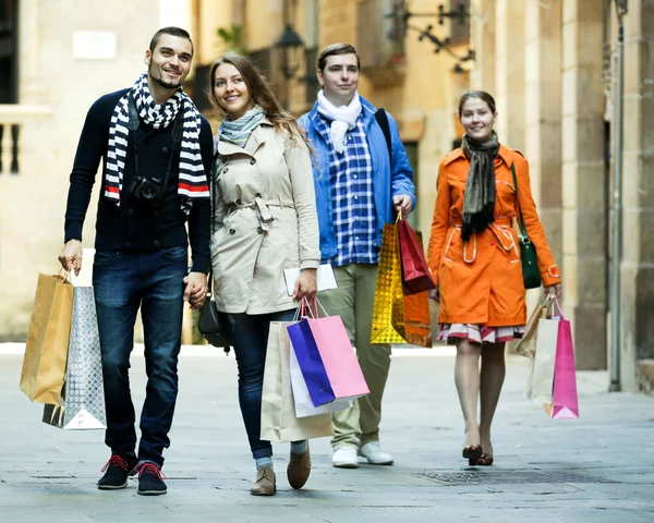 Group of young tourists with purchases — Stock Photo, Image