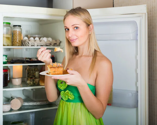 Vrouw die taart eet uit koelkast — Stockfoto