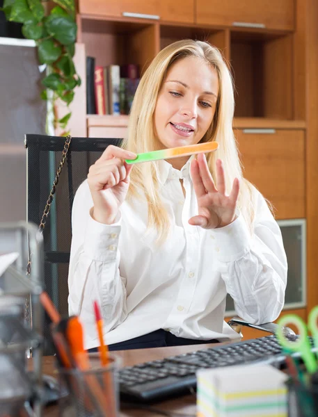 Frau macht Maniküre im Büro — Stockfoto