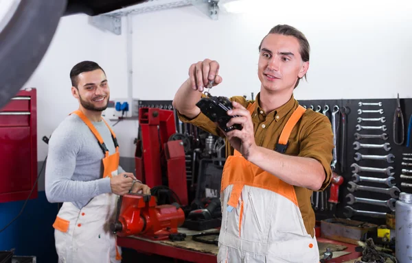 Twee arbeiders zwoegende in werkplaats — Stockfoto