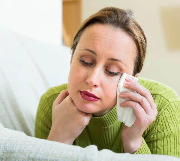 Upset woman in a couch — Stock Photo, Image