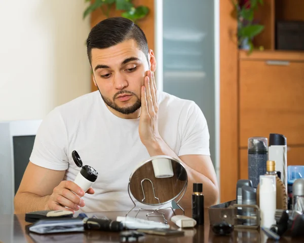 Man applying facial cream at home — Stock Photo, Image