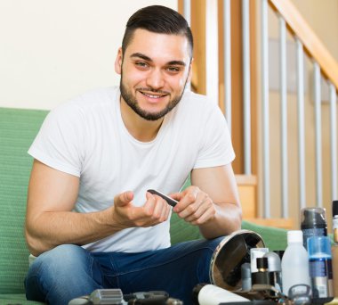 Young guy cutting nails clipart