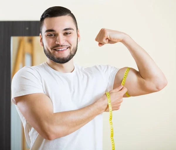 Mann misst seinen Bizeps — Stockfoto