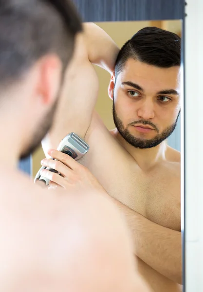 Молодой парень бреет подмышки — стоковое фото